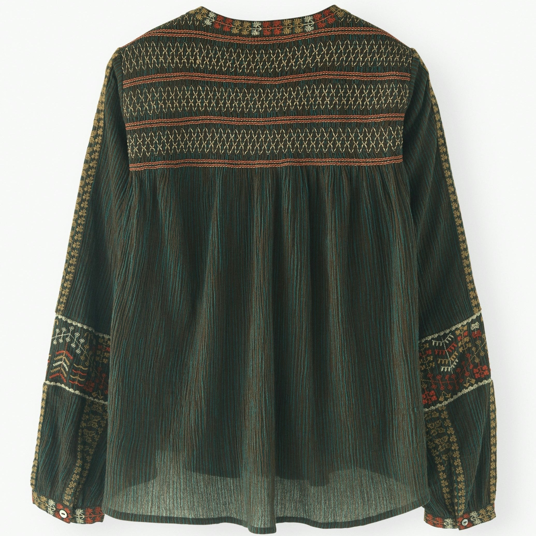 Green blouse with intricate patterns on a white background