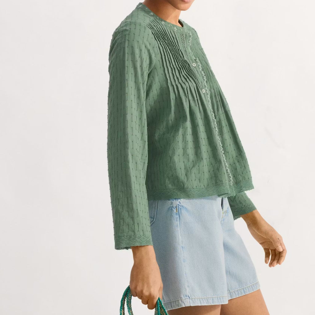 Woman holding a green and yellow striped bag against a white background